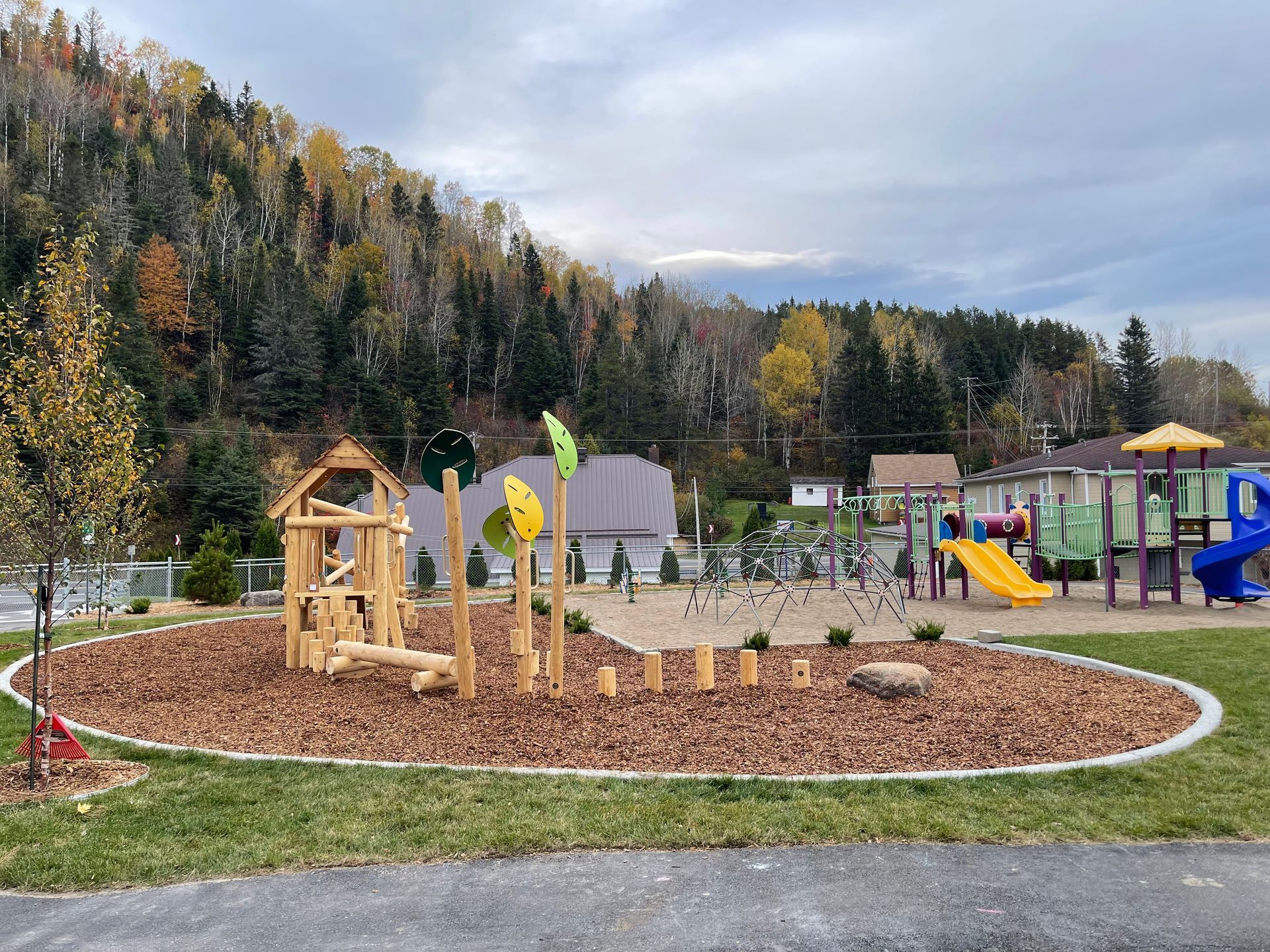 Une aire de jeux dans un parc avec des arbres en arrière-plan.