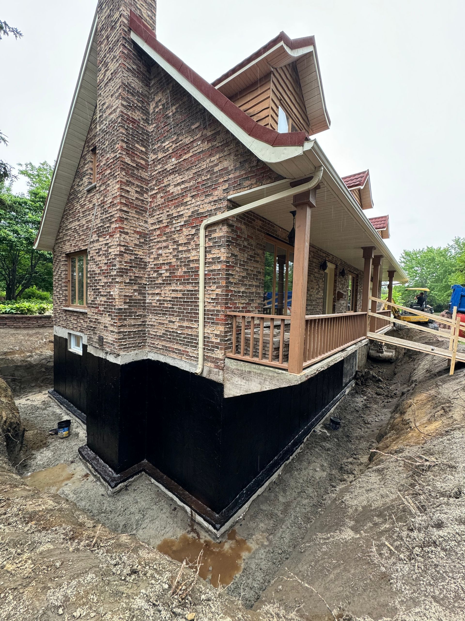 Une grande maison en briques avec un porche est en construction.