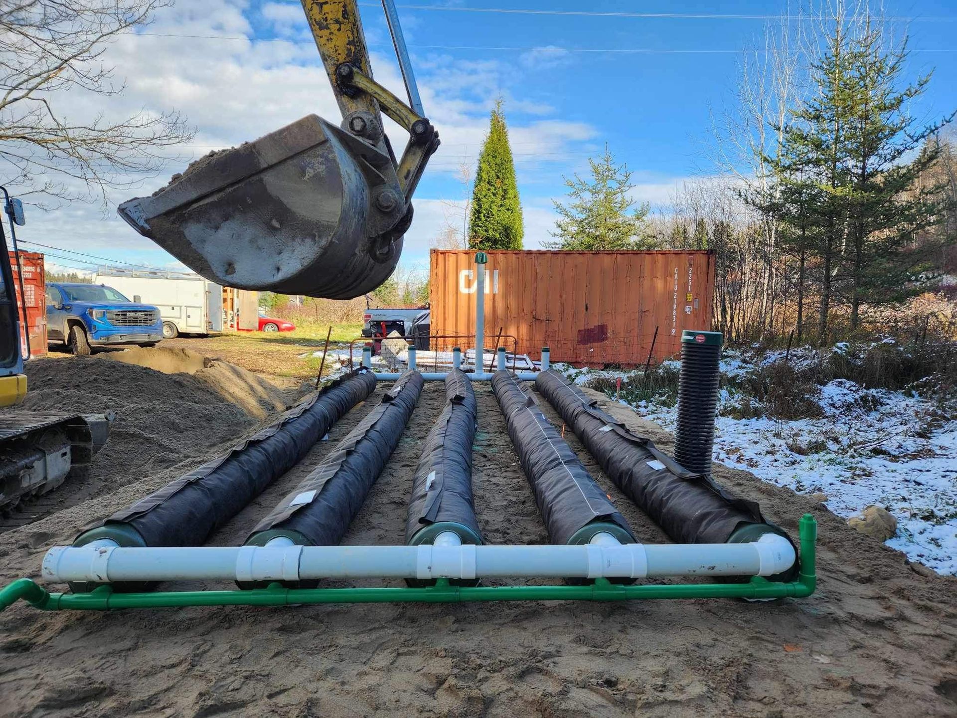 Un bulldozer creuse une tranchée de tuyaux dans la terre.