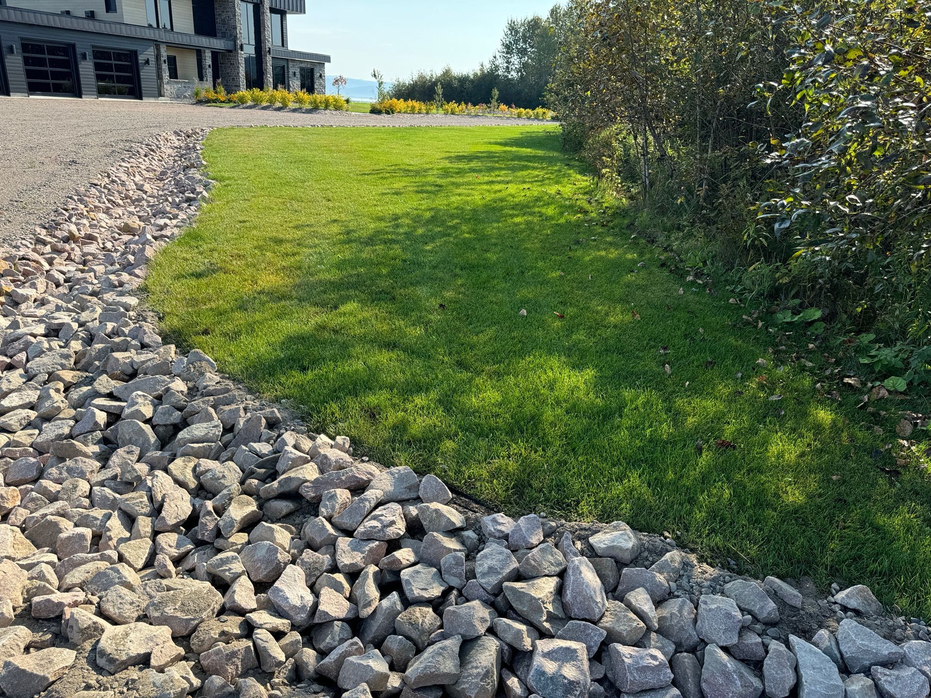 Un tas de rochers se trouve à côté d'une pelouse verte luxuriante.