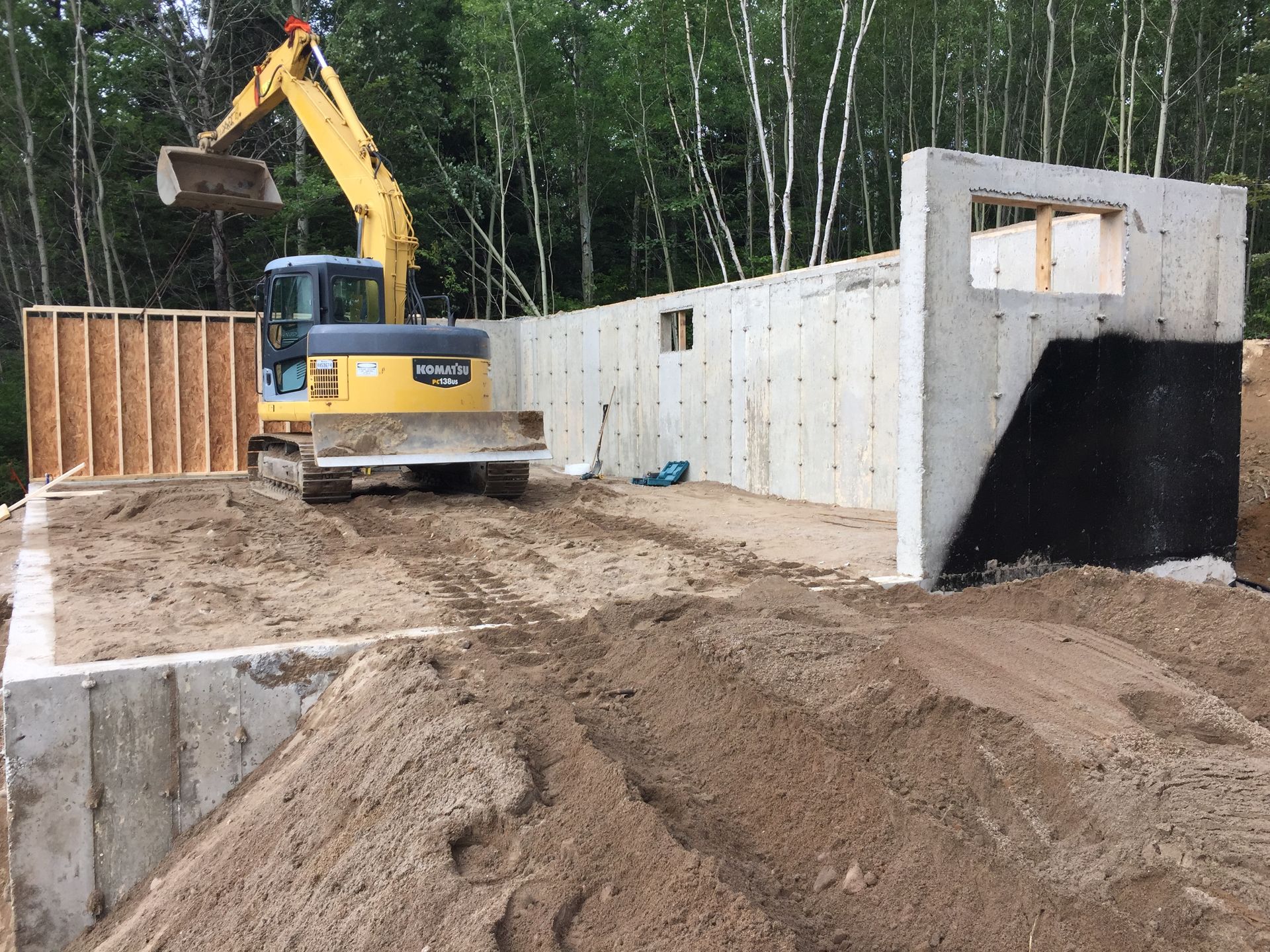 Une excavatrice jaune travaille sur un chantier de construction.