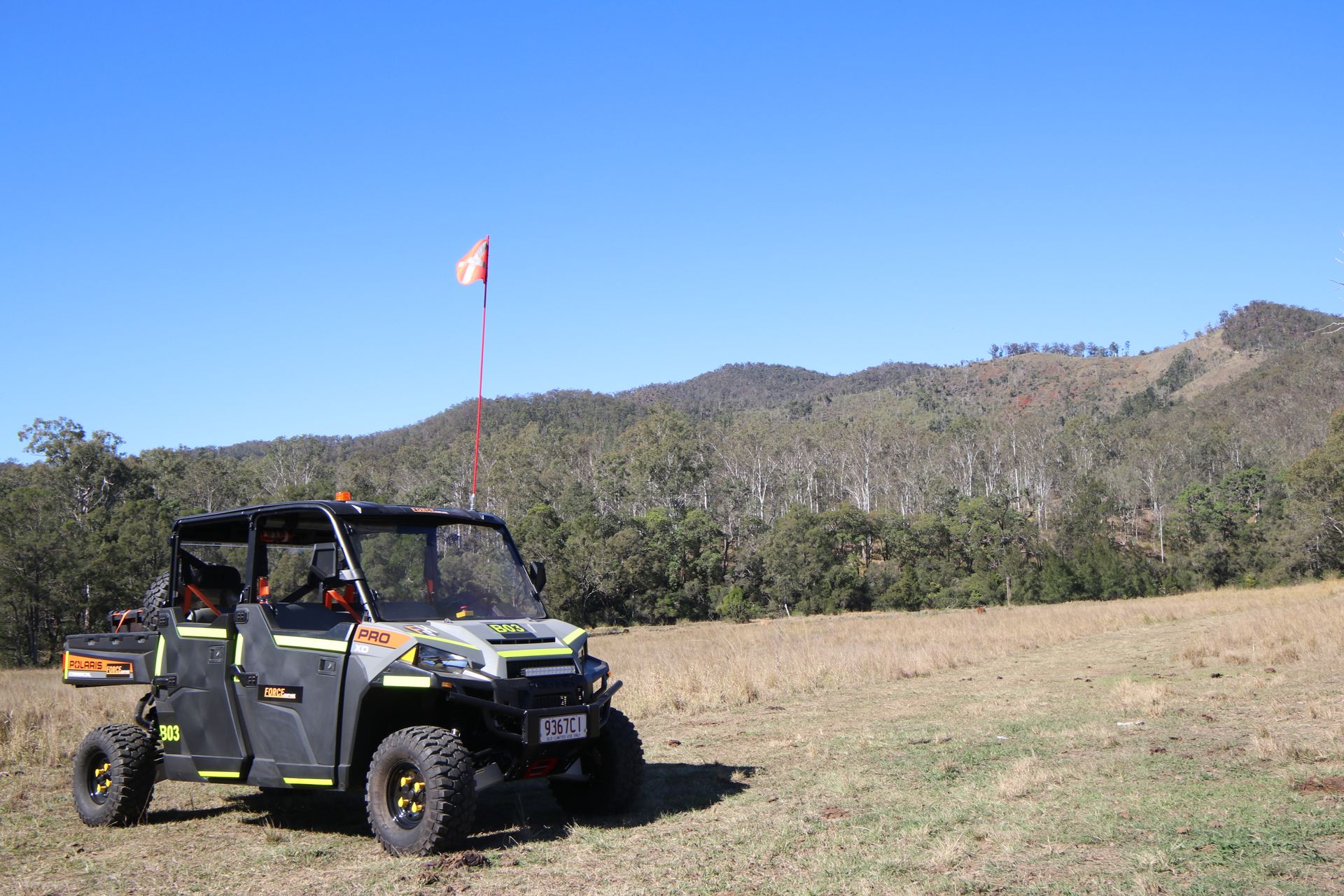 A Atv Is Parked In A Field With Mountains In The Background — Forcequip Hire In Southside, QLD