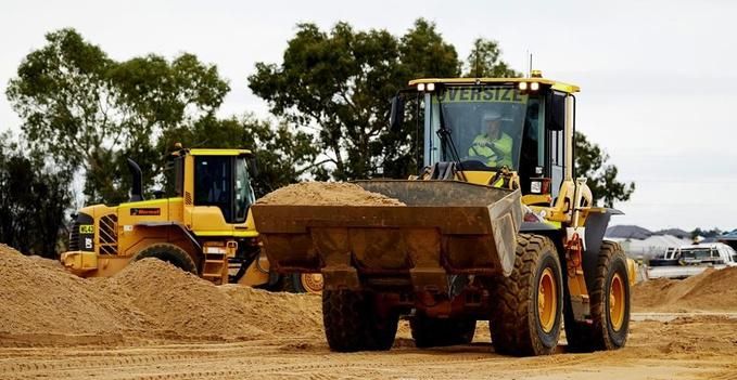 A man is driving a bulldozer on a dirt road — Forcequip Hire In Southside, QLD