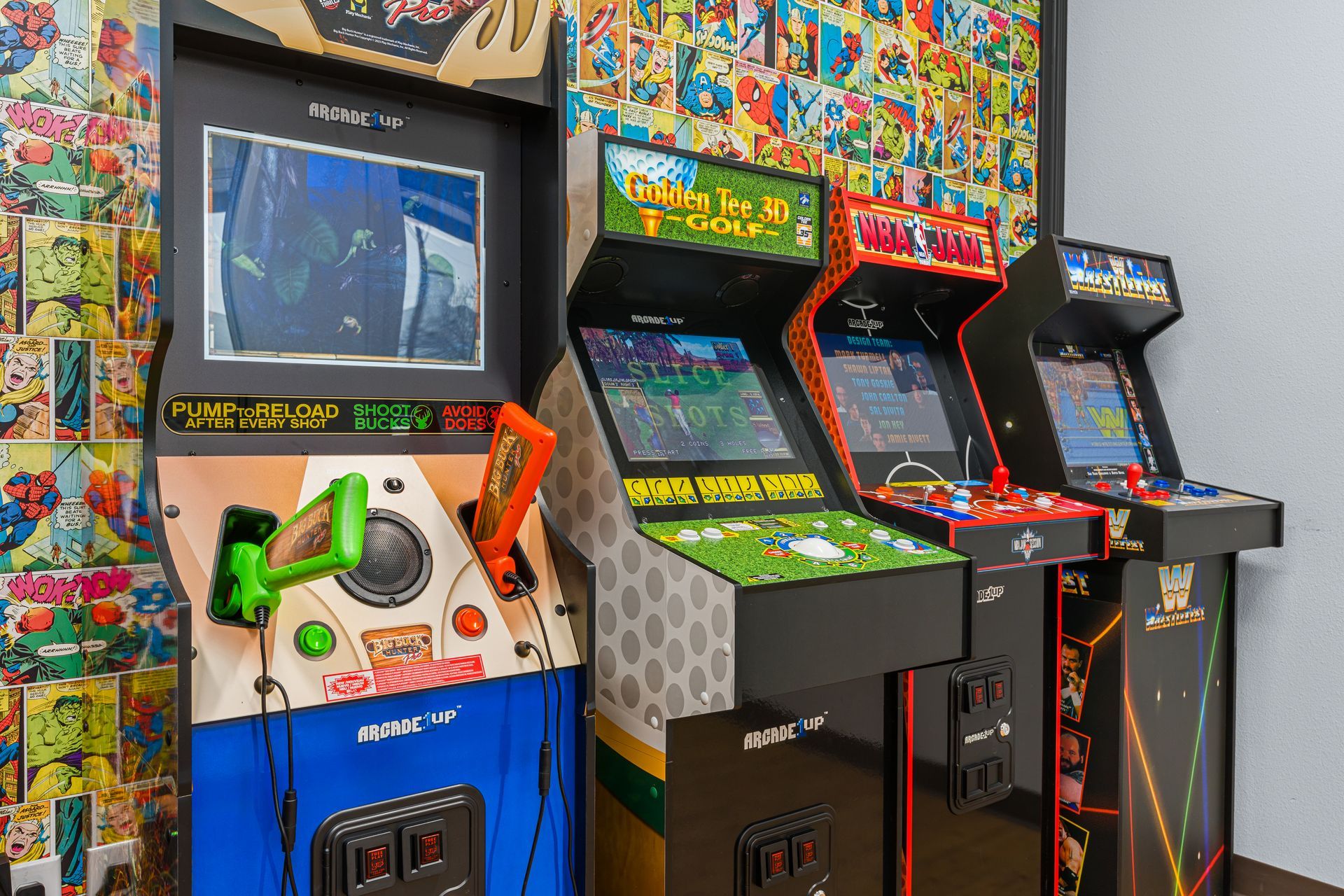 Lucent Orthodontics, San Antonio. A row of three Arcade1Up arcade cabinets against a comic-book patterned wall in an indoor setting.