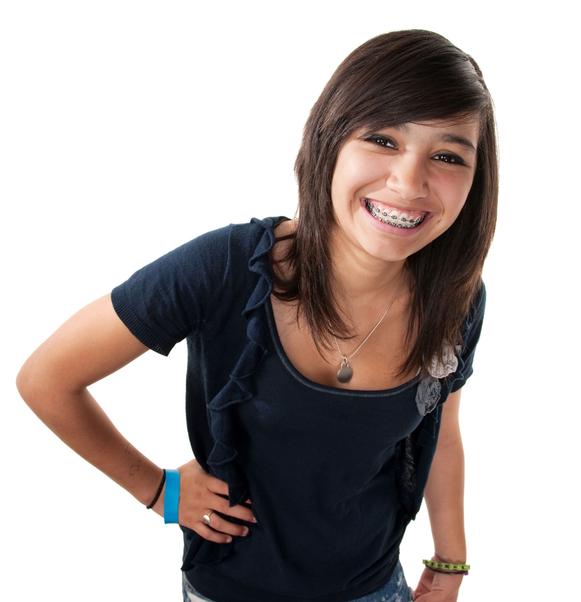 A smiling person with braces, wearing a dark blue short-sleeved top and a silver necklace, poses against a white background.