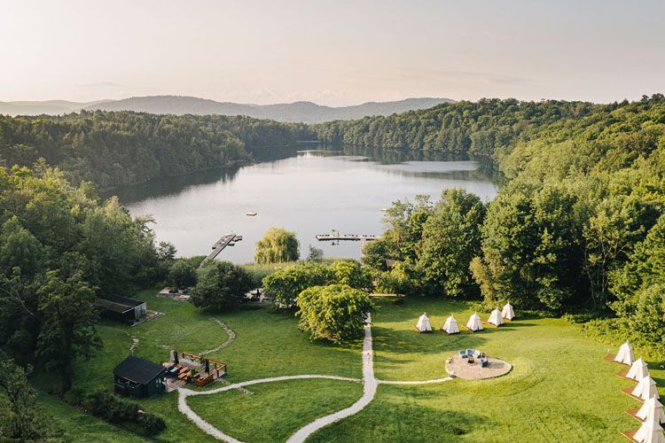 Une vue aérienne d'un lac entouré d'arbres et d'herbe et d'installations d'une réserve thermale.