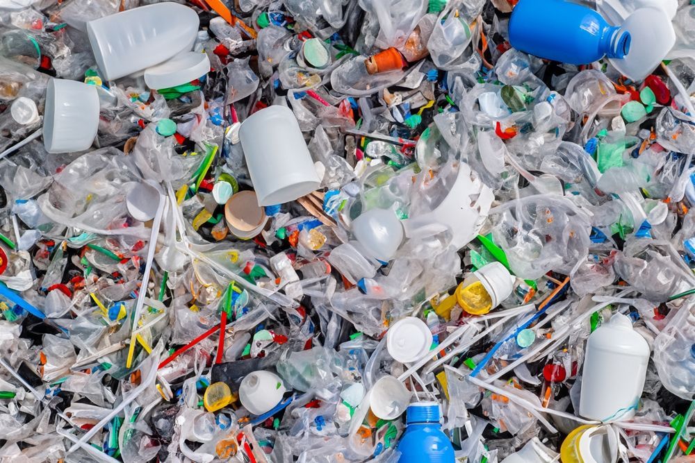 Pile of mixed plastic waste, including bottles, containers, and straws.