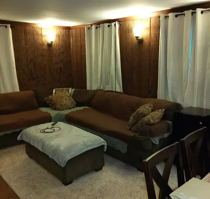 A living room with a couch ottoman and chairs