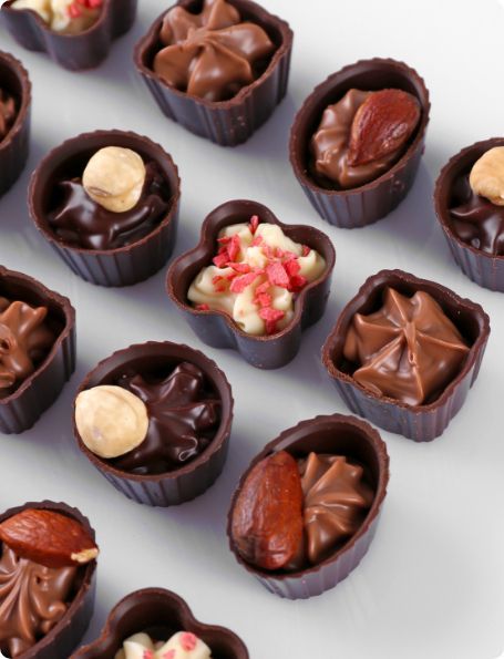 A bunch of chocolate cups filled with different types of chocolates