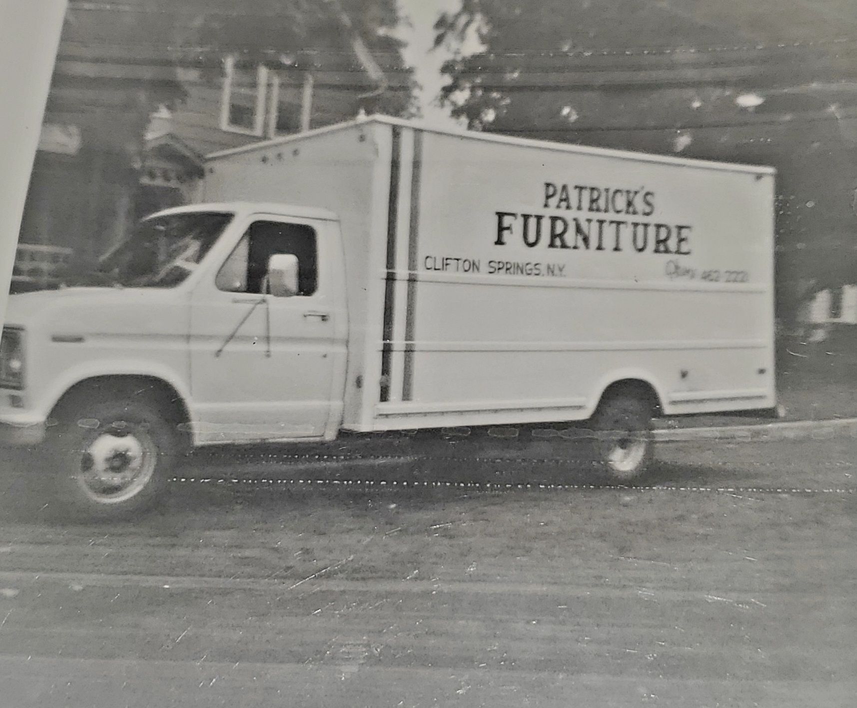 White Patrick's Furniture truck on street, Clifton Springs, NY. Text and phone number on the truck.