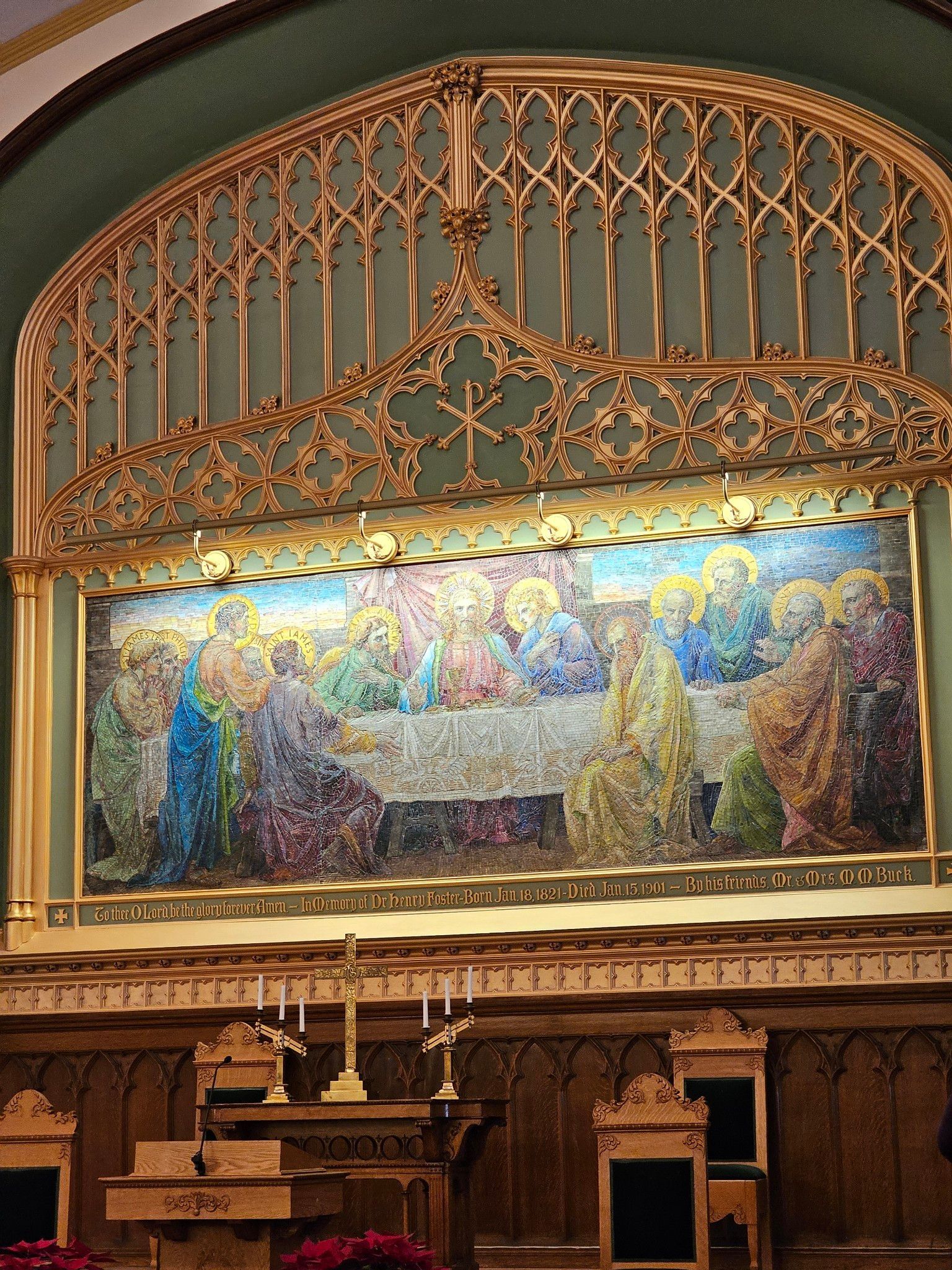 Mosaic of the Last Supper above a wooden altar in a church. Ornate gold detailing and candles are visible.