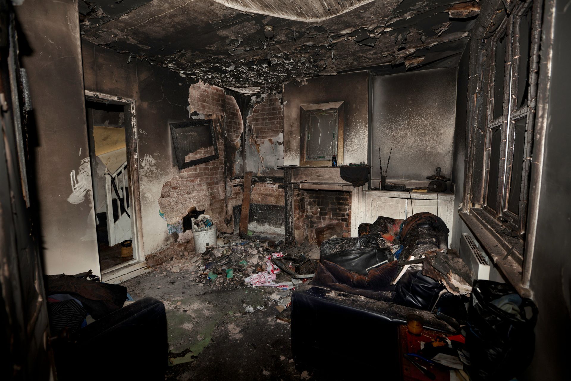 A fire-damaged living room showcasing emergency fire damage restoration services.