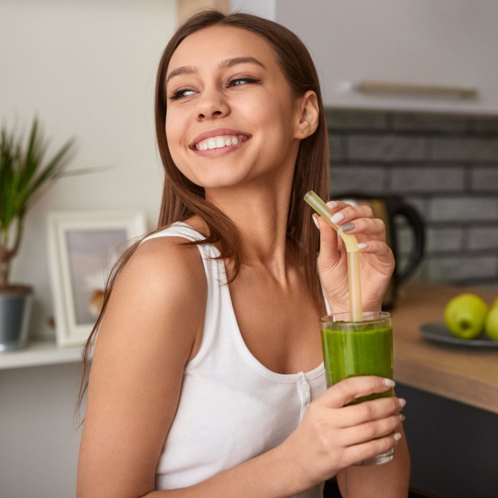 A Woman is Drinking a Green Smoothie With a Straw — Your Body Revolution in Caloundra, QLD