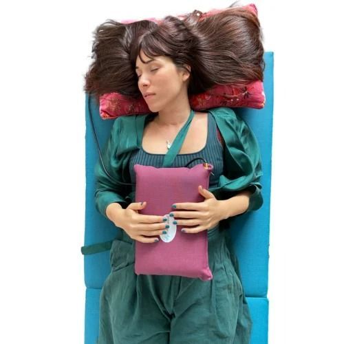 A Woman is Laying on a Bed Holding a Pink Pillow — Your Body Revolution in Caloundra, QLD