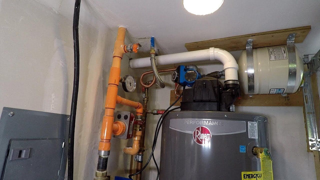 A man is working on a pipe with a wrench.