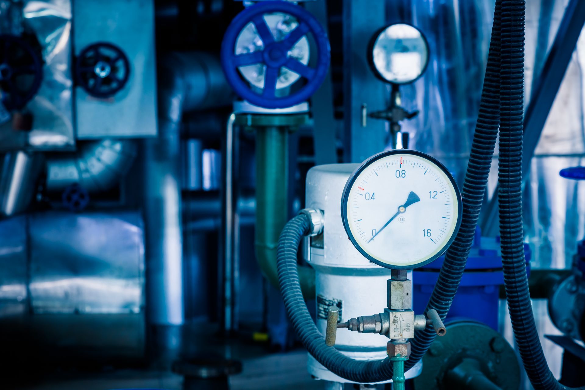 A close up of a pressure gauge in a factory.