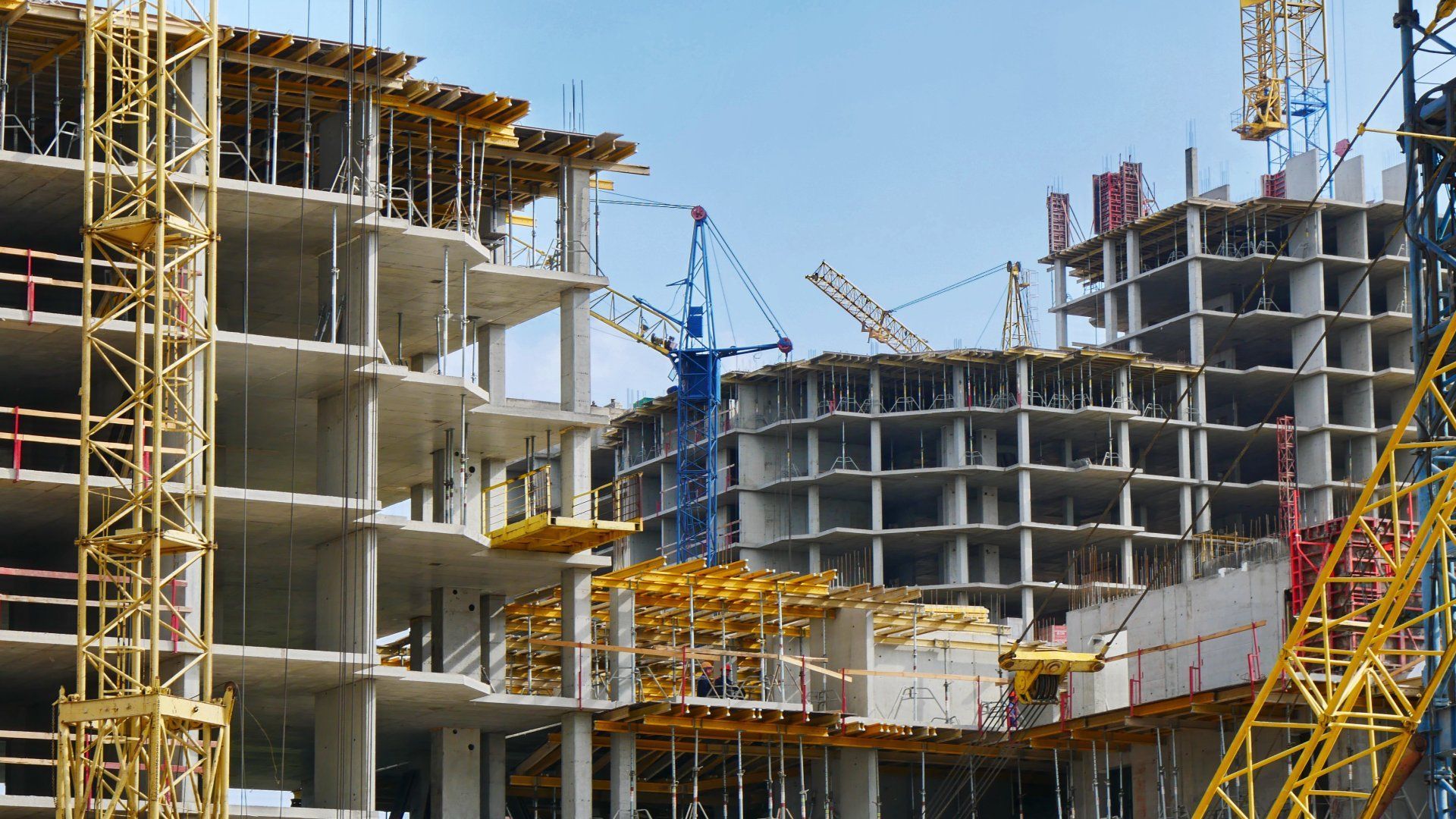 A large building is being built with cranes and scaffolding.