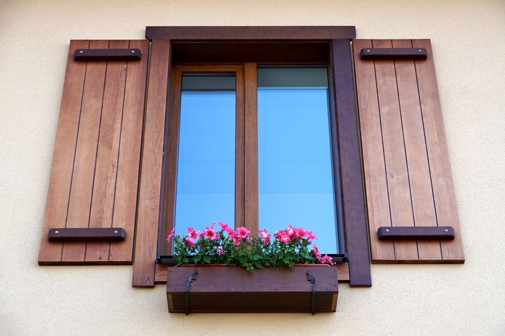 A Window With Wooden Shutters And Flowers In A Window Box — K & S Windows In Ciccone, NT