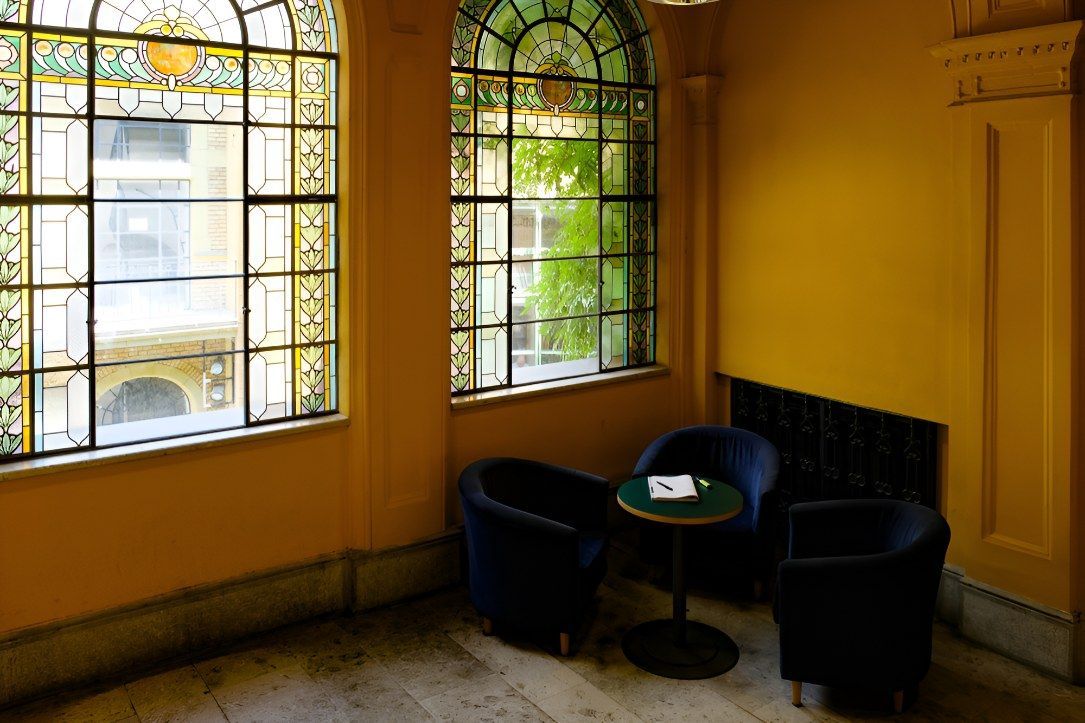 Two Chairs And A Table In A Room With Stained Glass Windows — K & S Windows In Ciccone, NT