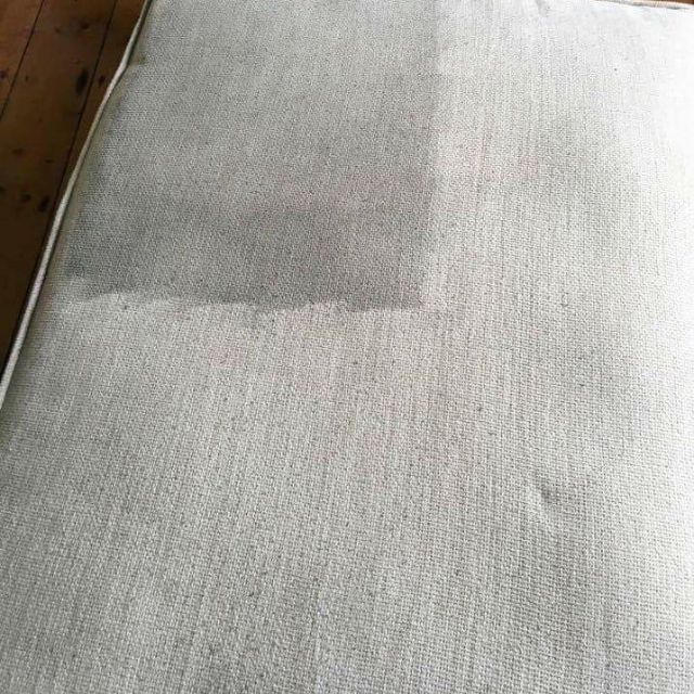 A close up of a couch cushion on a wooden floor.