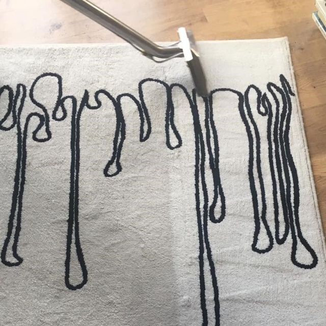 A white rug with a black design on it