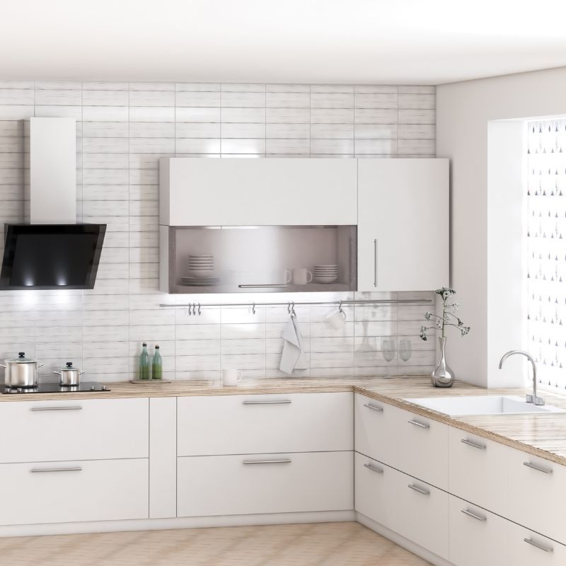 White modern kitchen with cabinets, stainless steel appliances, and light wood countertops.