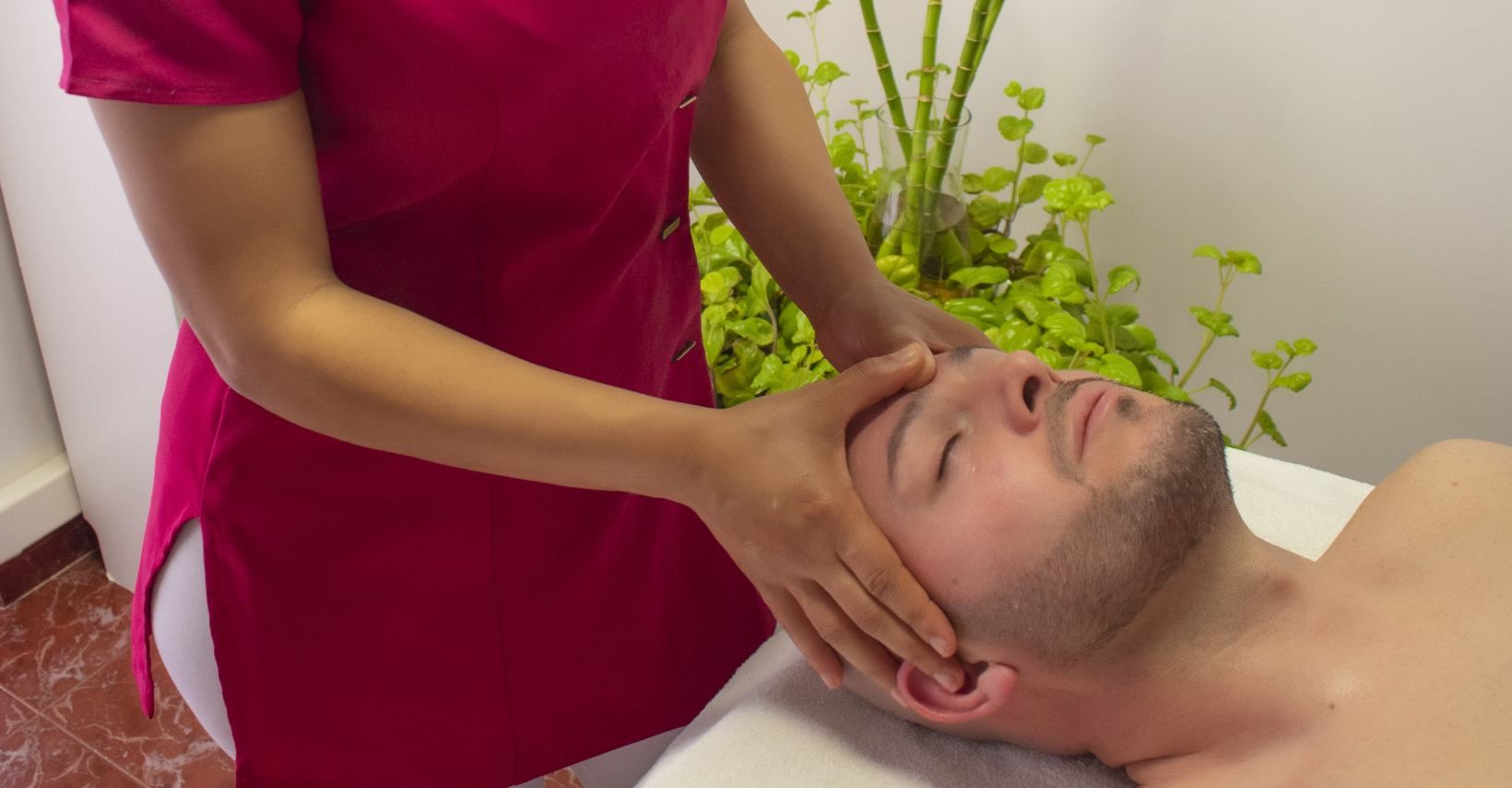 un hombre recibe un masaje en la cabeza en un spa.