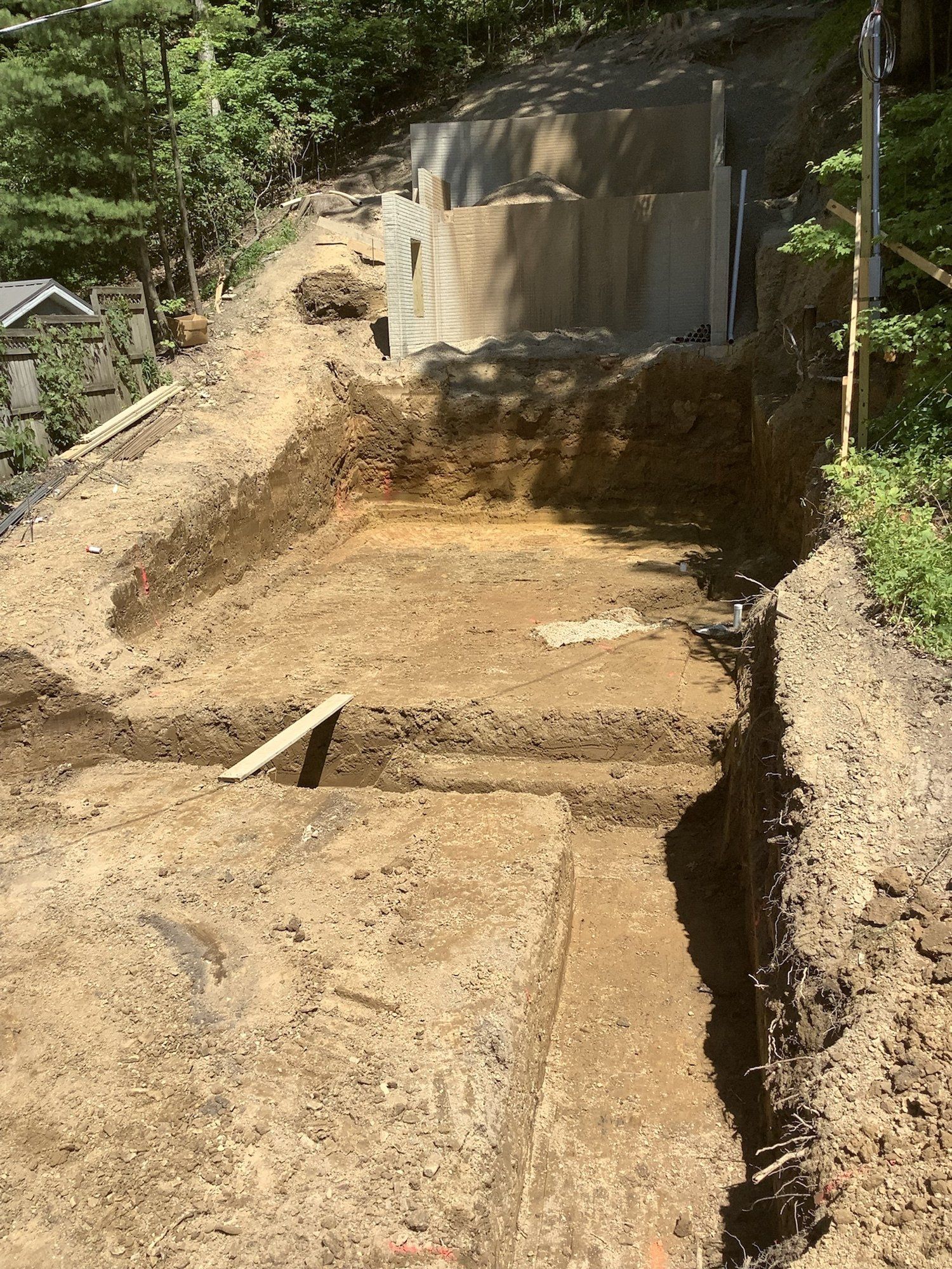 Excavation for a pool. Soil and retaining walls in outdoor, hillside setting.