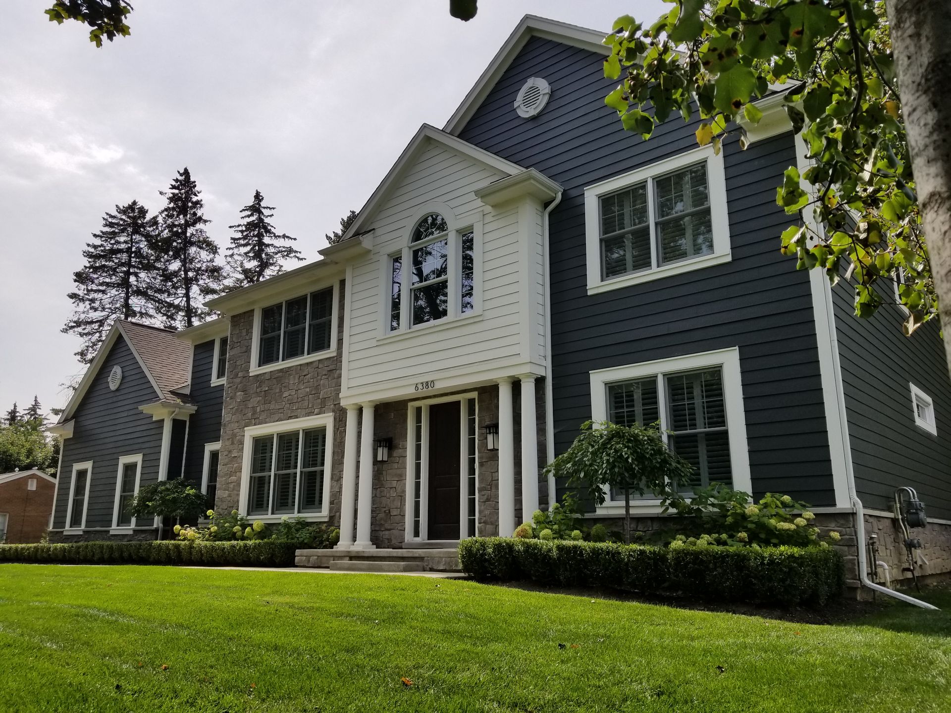 A large house with a lush green lawn in front of it