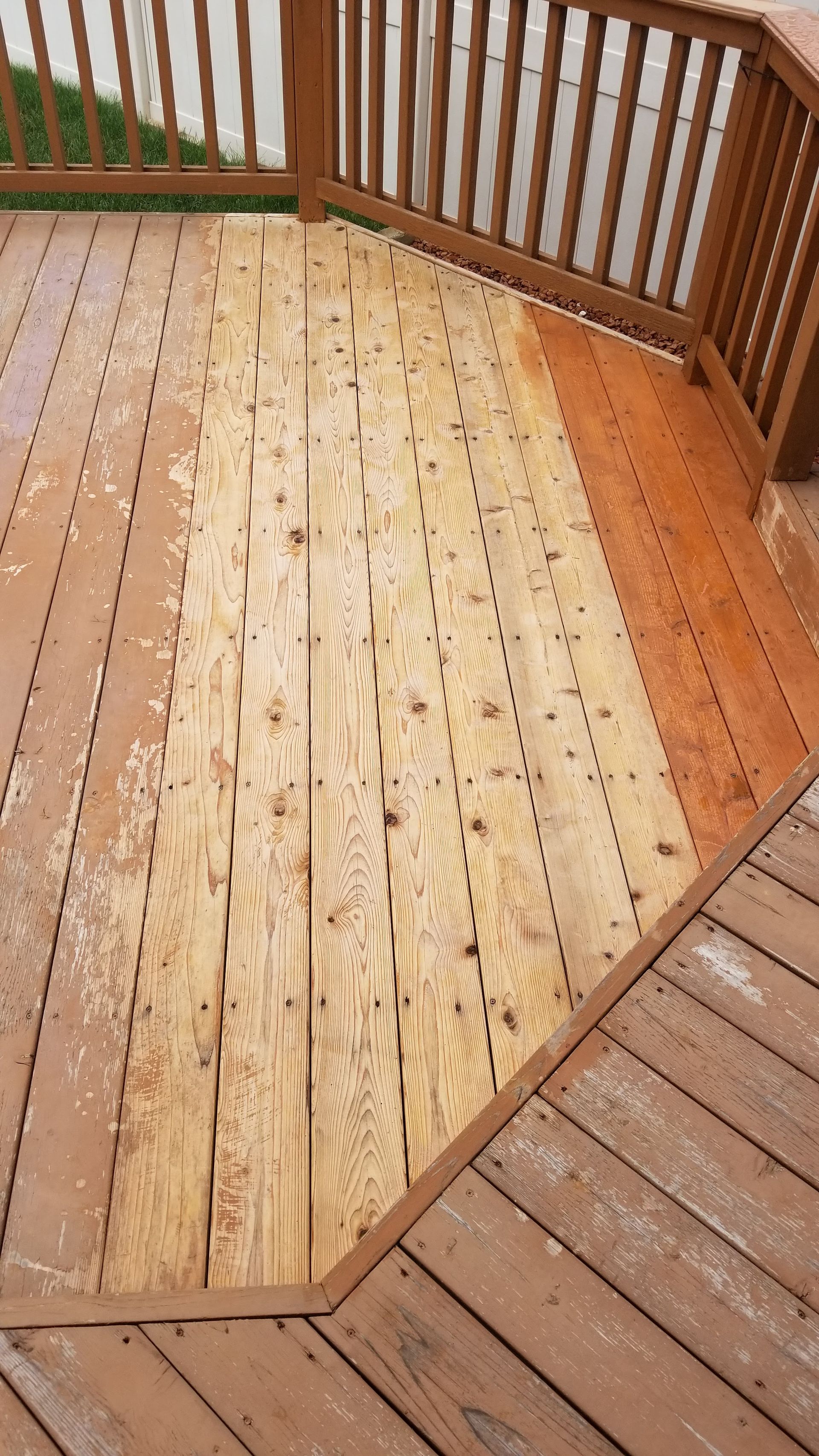 A wooden deck with a railing and a piece of plywood on it.