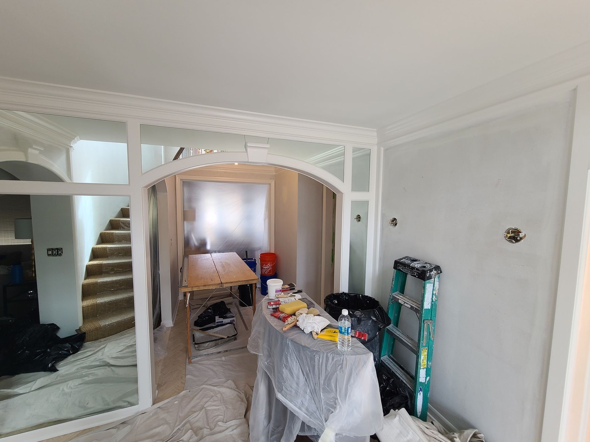 A room with a table and a ladder in it is being painted.