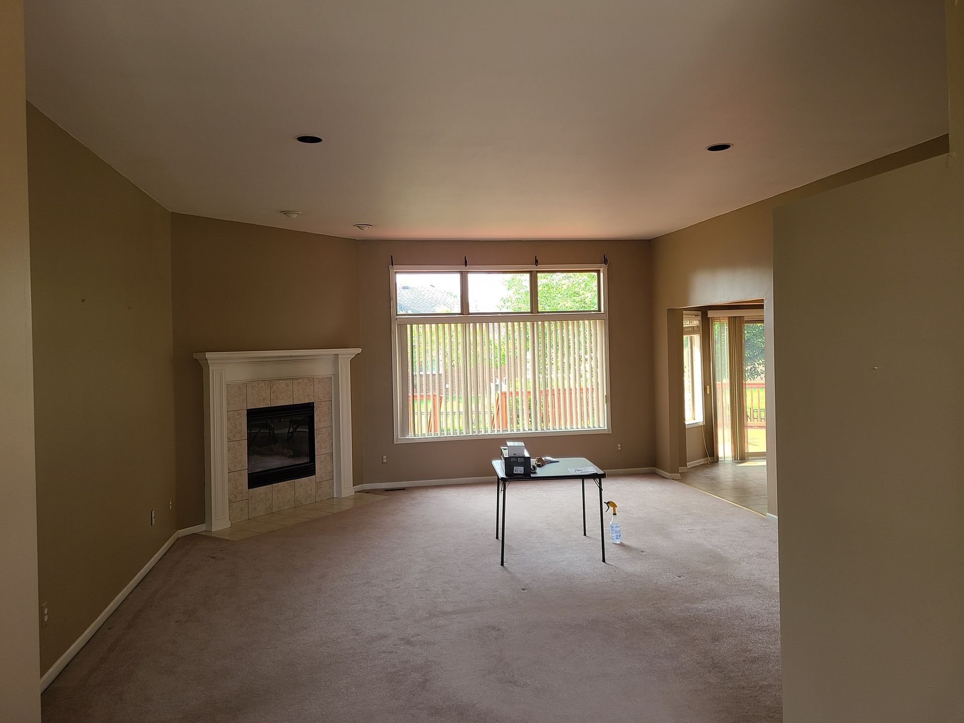 An empty living room with a fireplace and a table