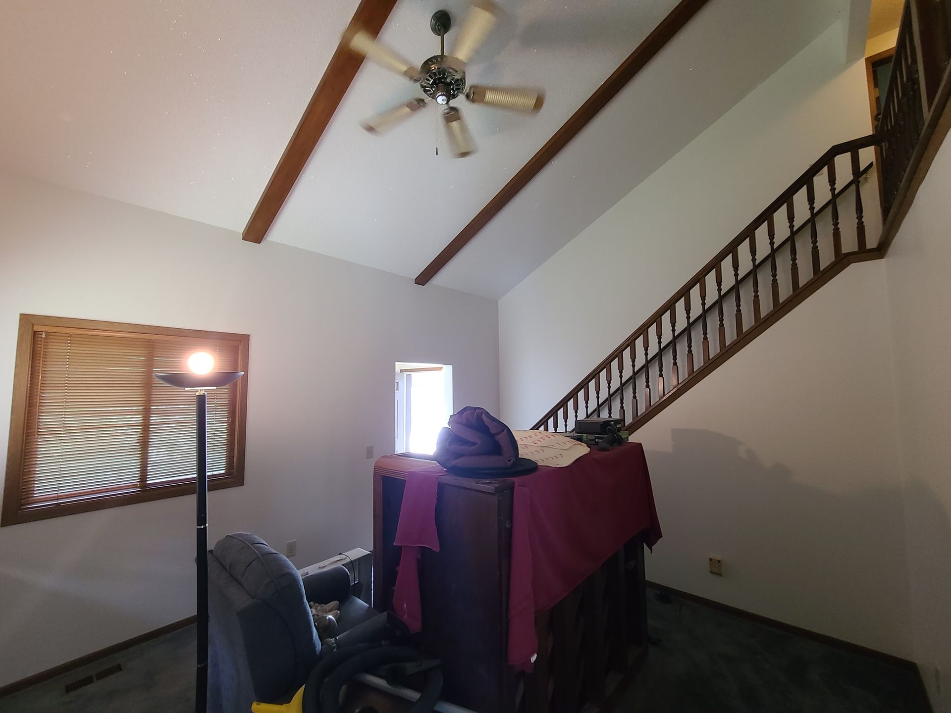 A living room with a staircase and a ceiling fan