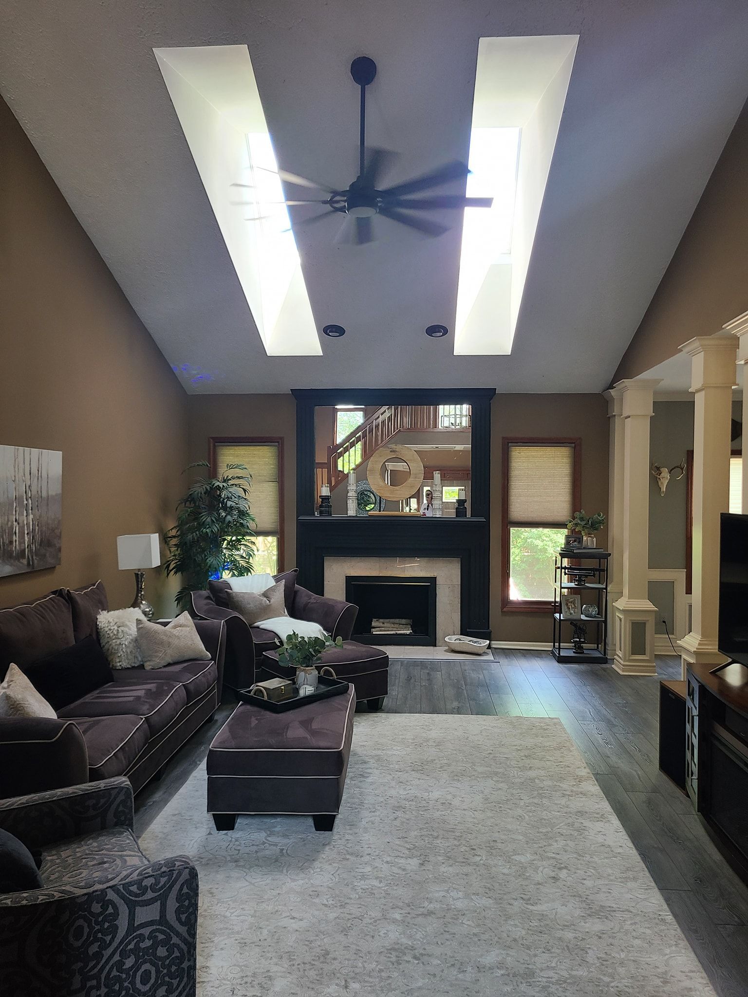 A living room with a fireplace and a ceiling fan