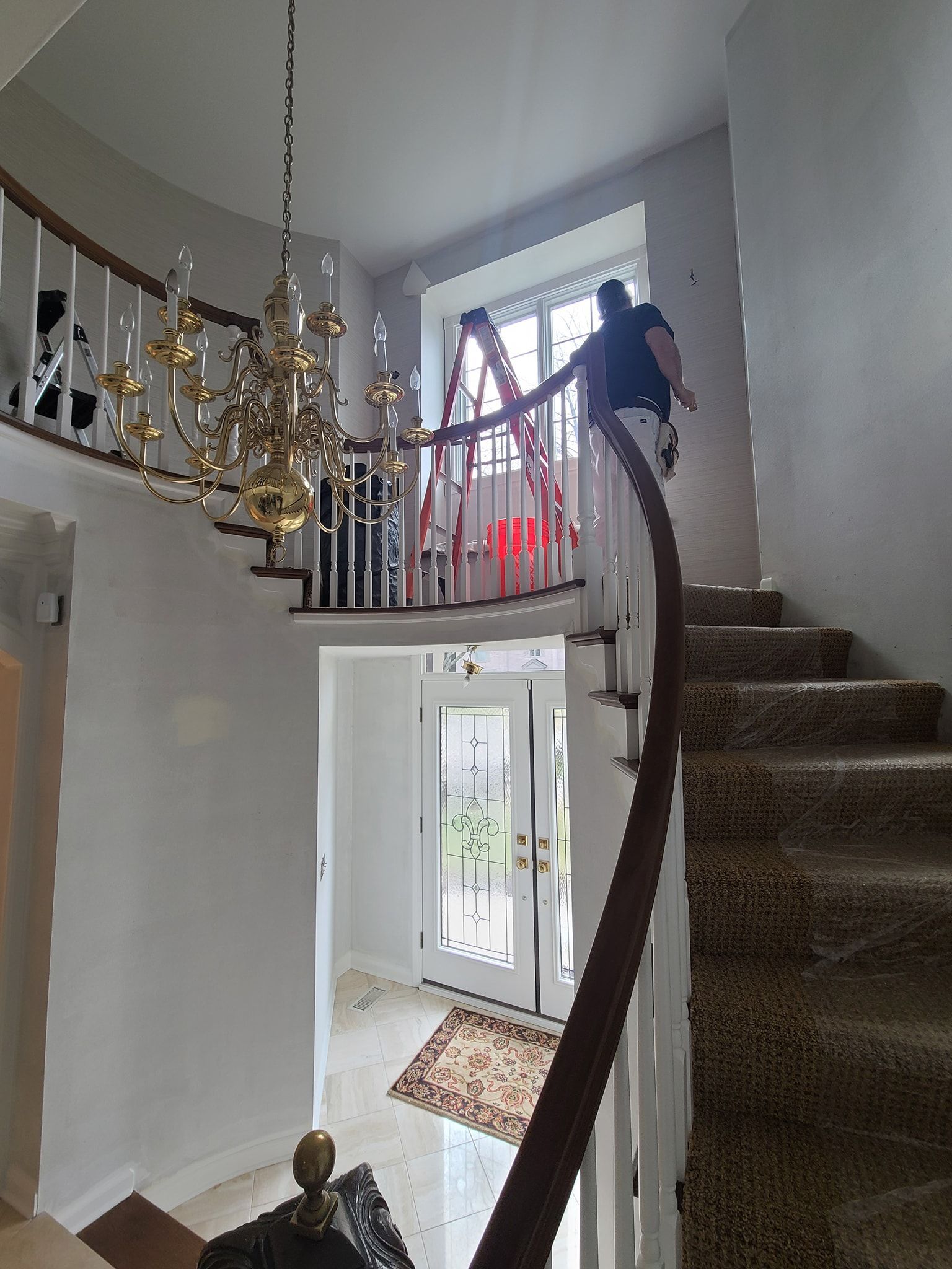 A man is standing on a curved staircase in a house.