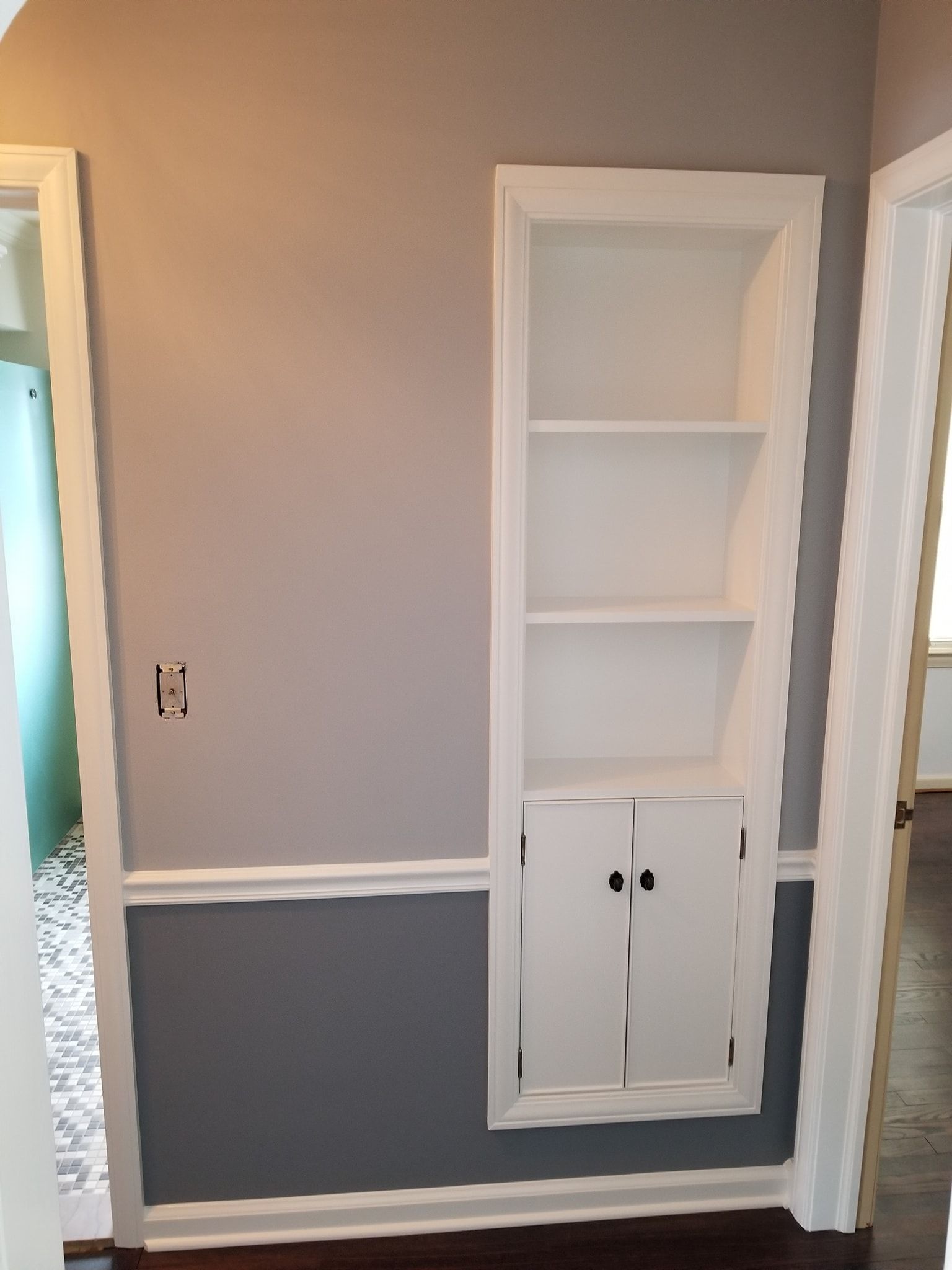 A hallway with a bookshelf and a door