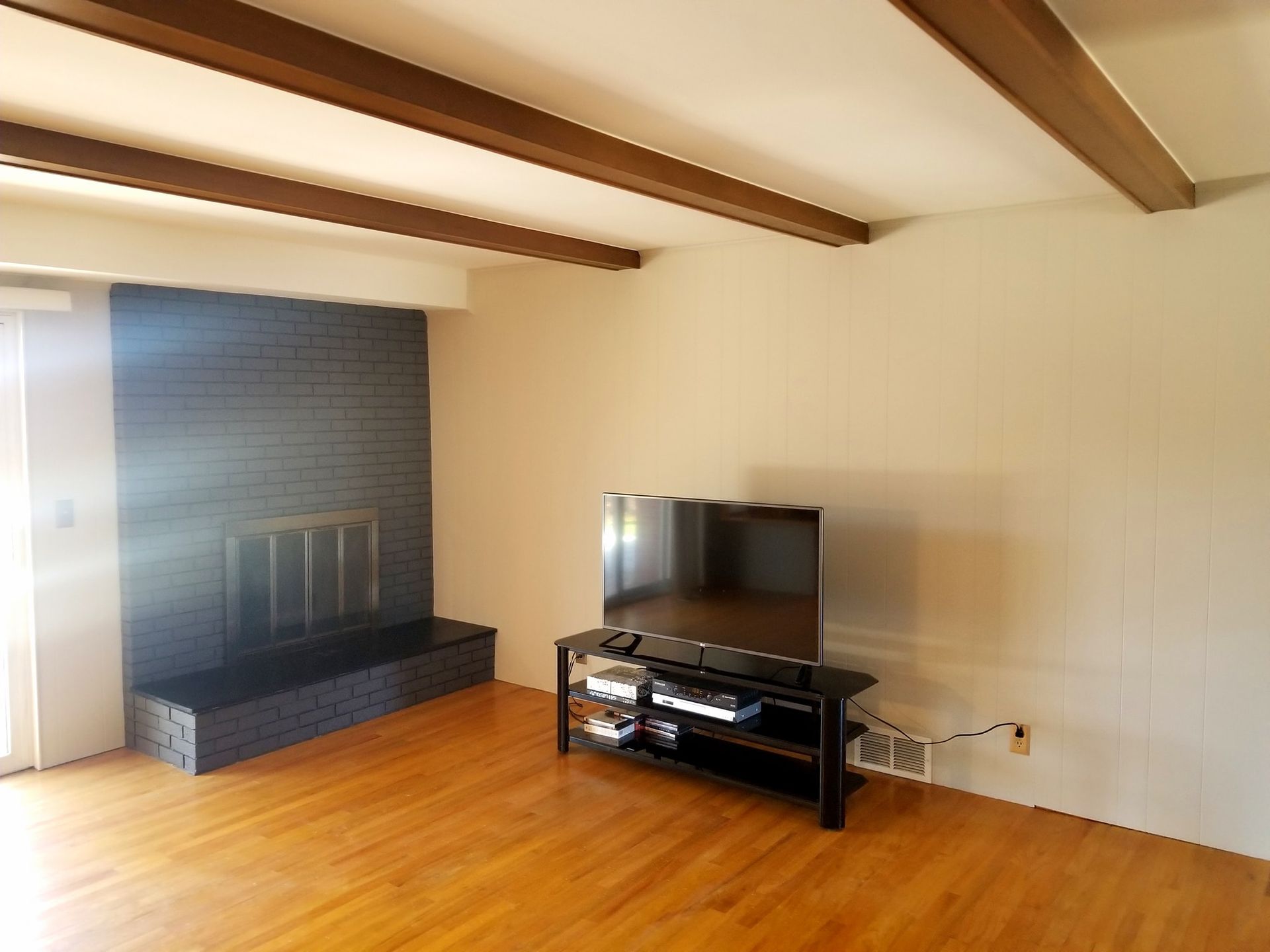 A living room with a fireplace and a flat screen tv