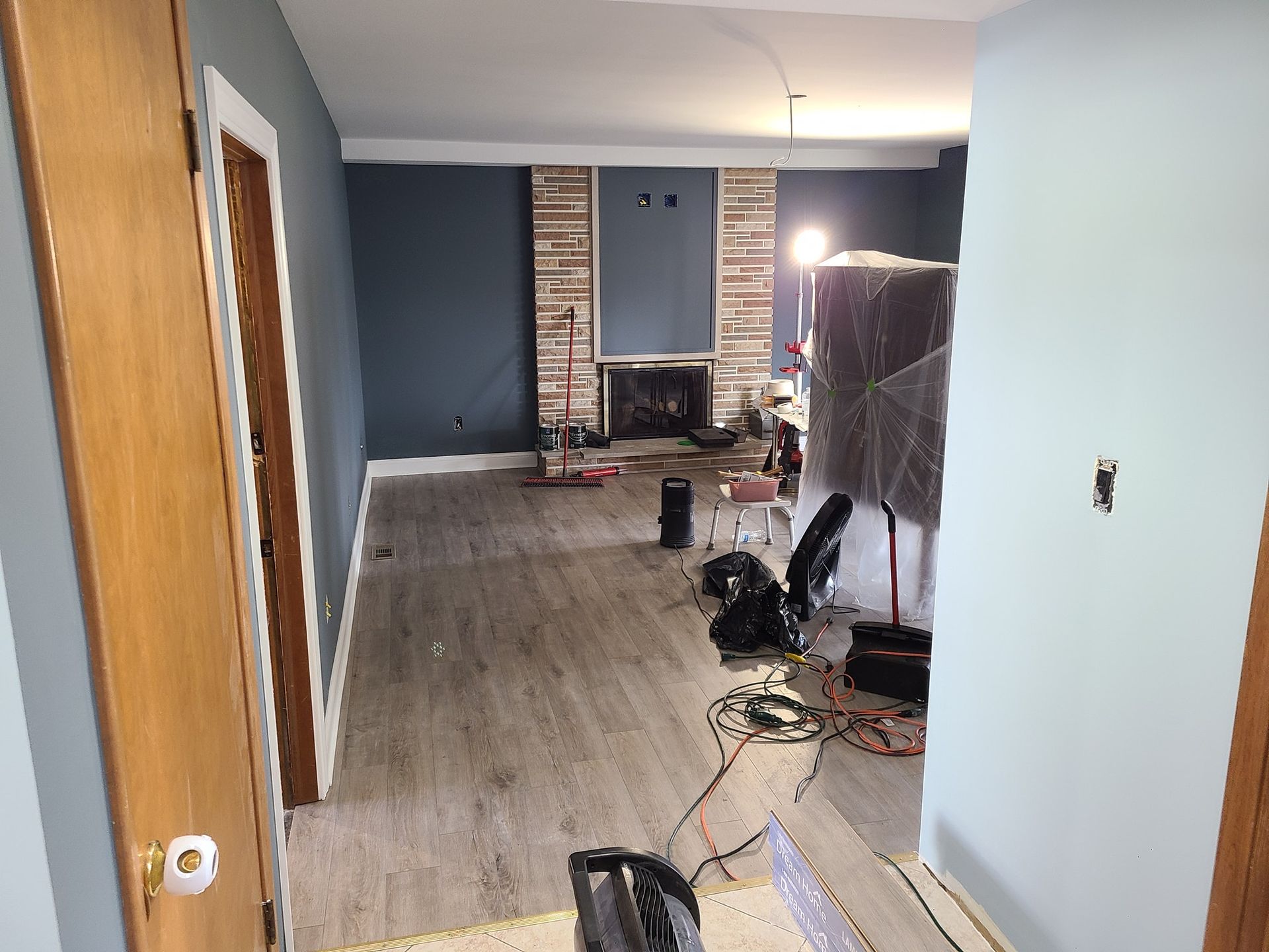 A living room with hardwood floors and a fireplace under construction.