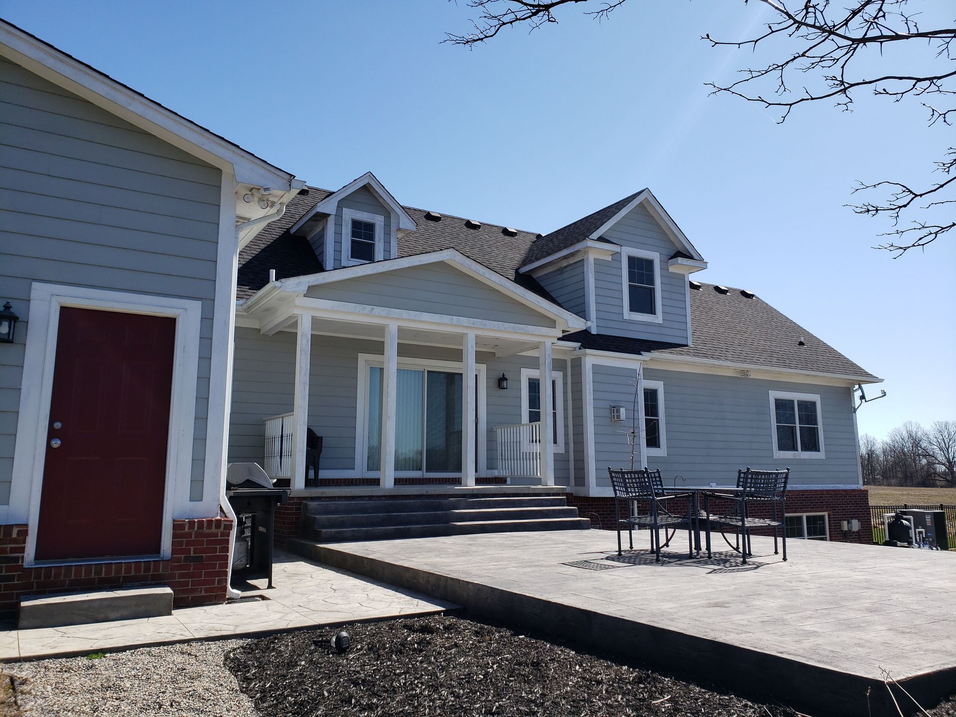 A room with purple walls , a dresser , and two windows.