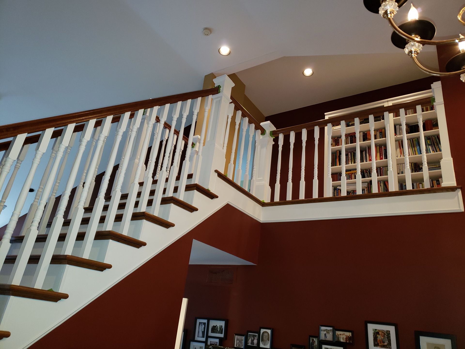 A staircase with a white railing and red walls