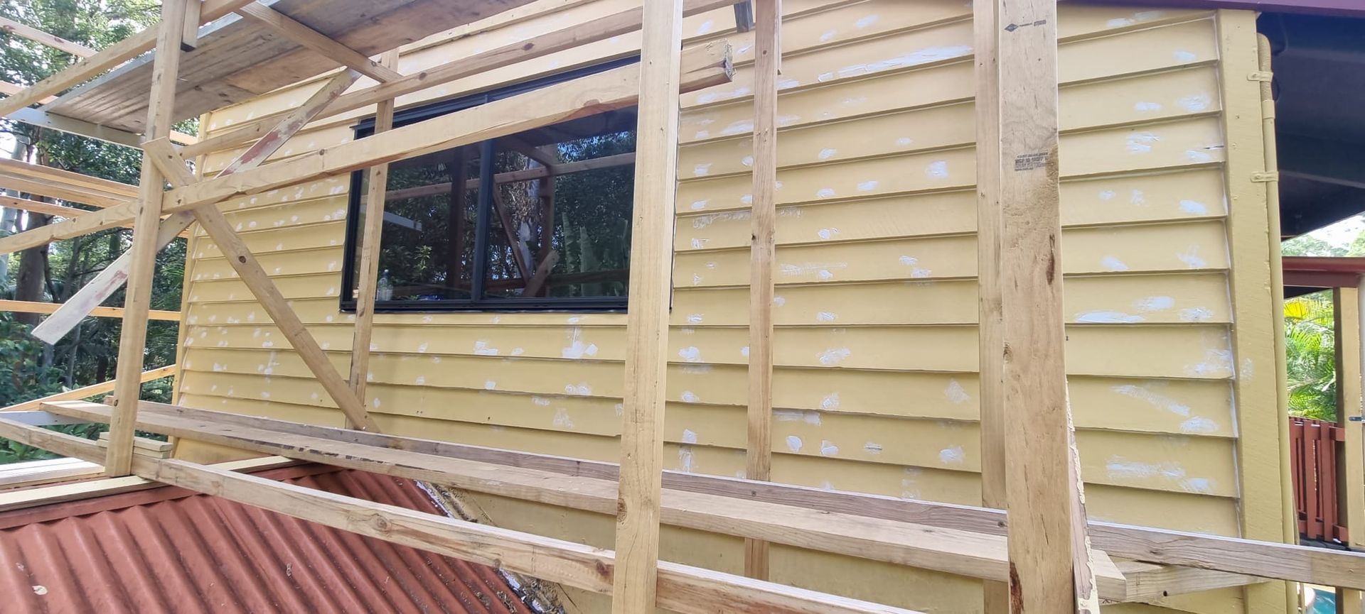 A wooden scaffolding is being used to build a house.