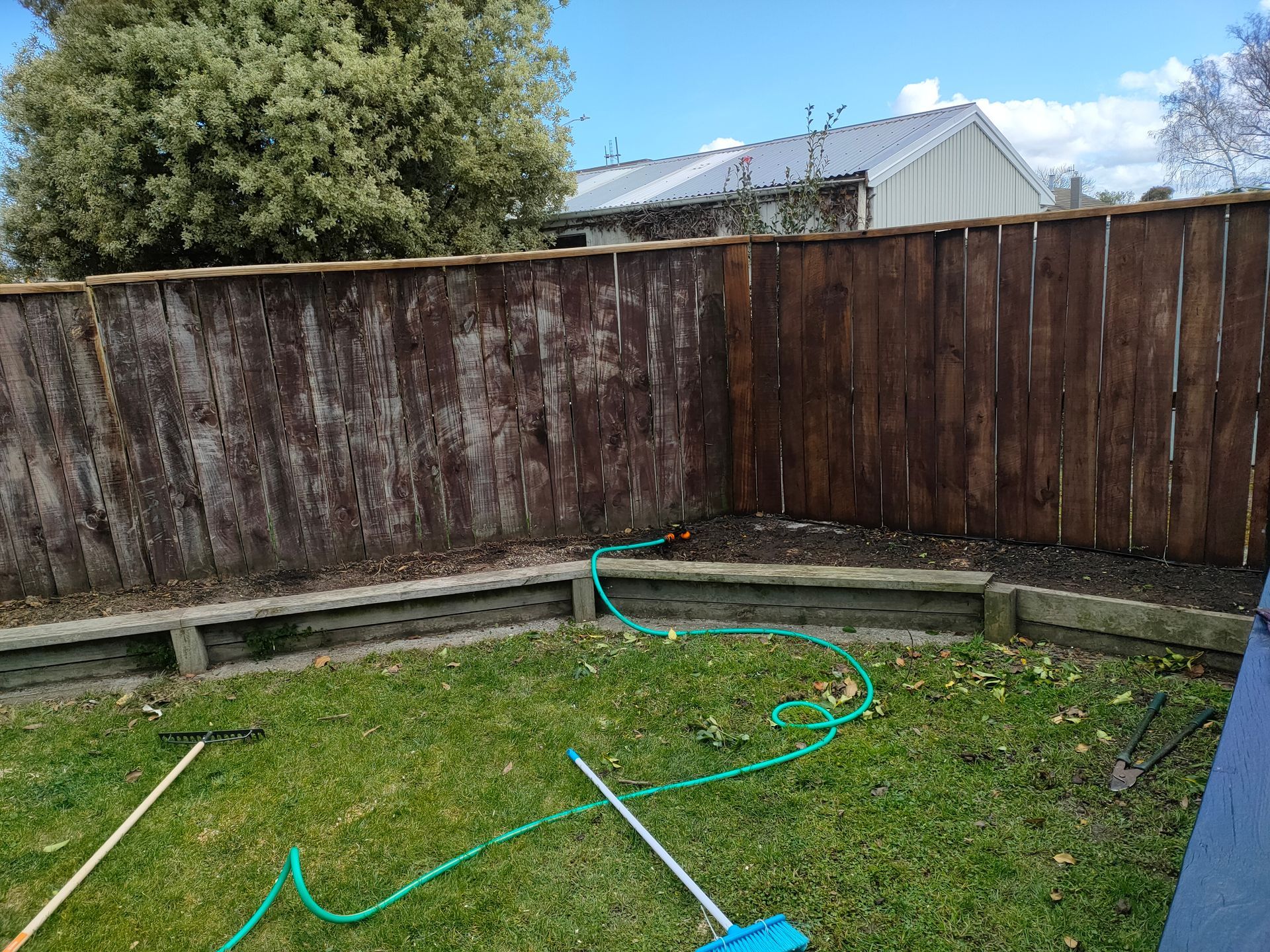 A wooden fence is sitting in the middle of a lush green yard.