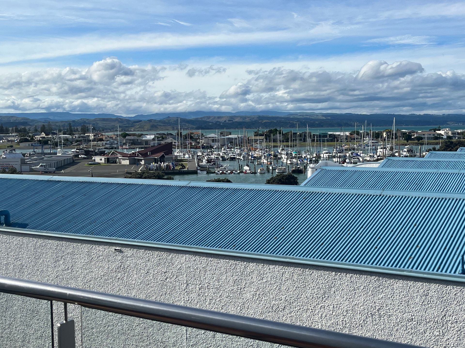 A view of a city from a balcony with a blue roof.