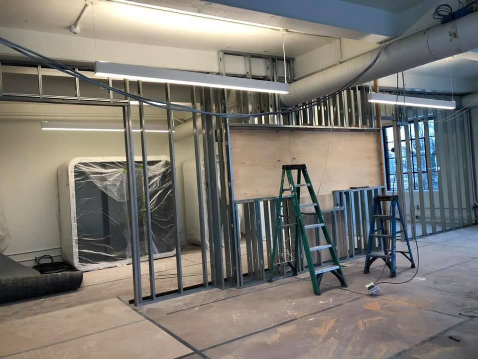 A room under construction with a ladder in the middle of it.