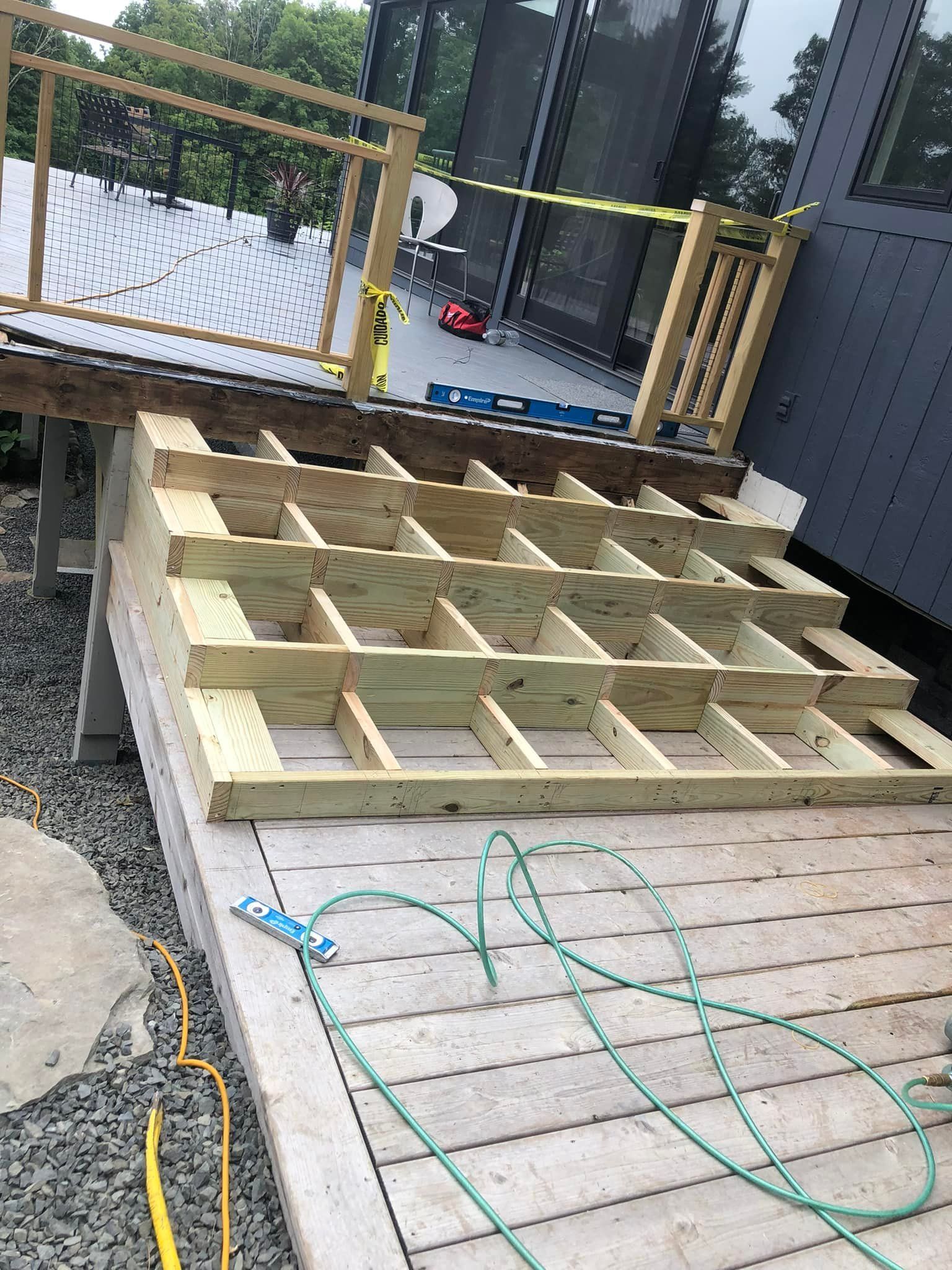 A wooden deck is being built next to a building.
