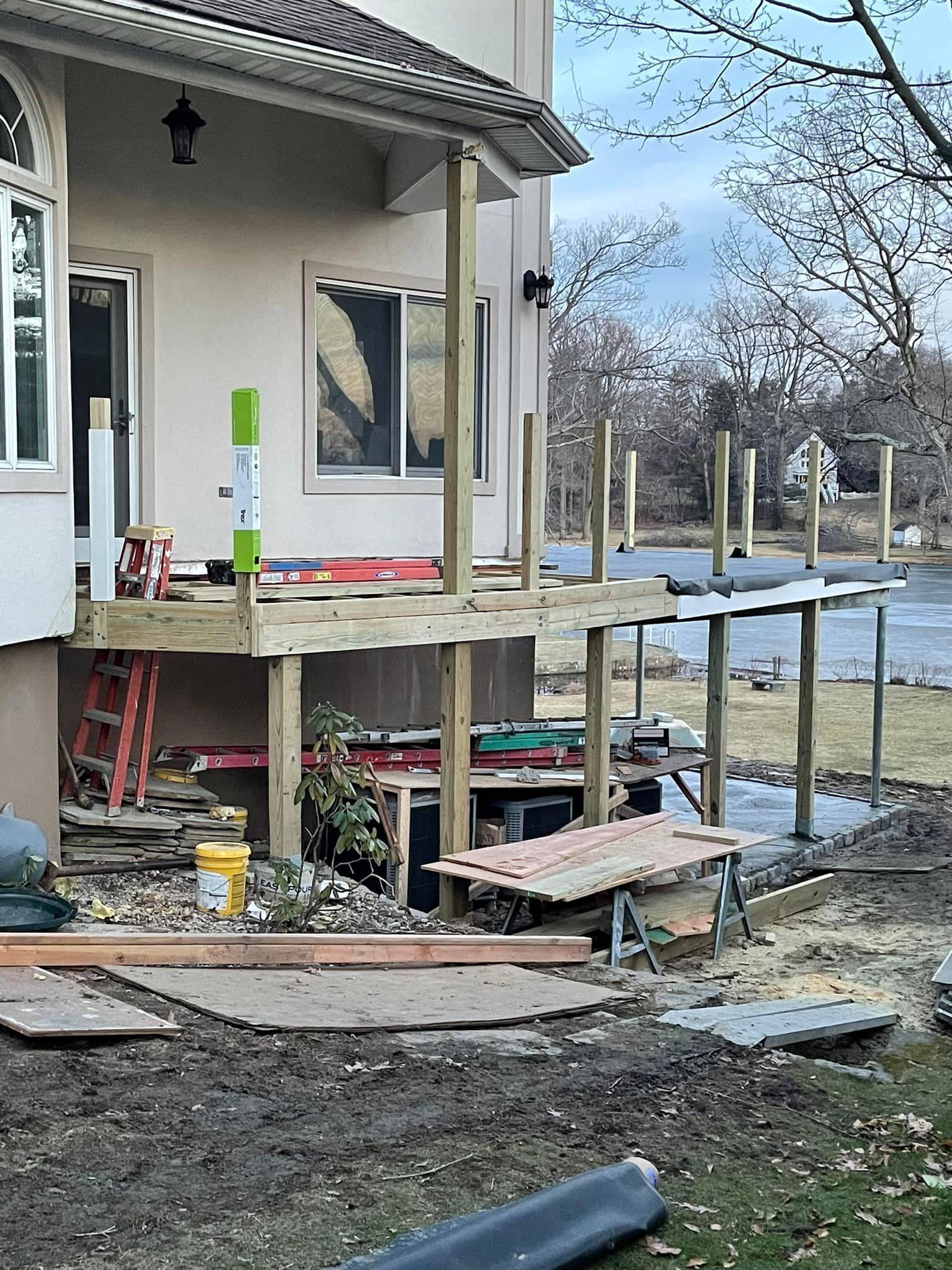 A wooden deck is being built in front of a house.