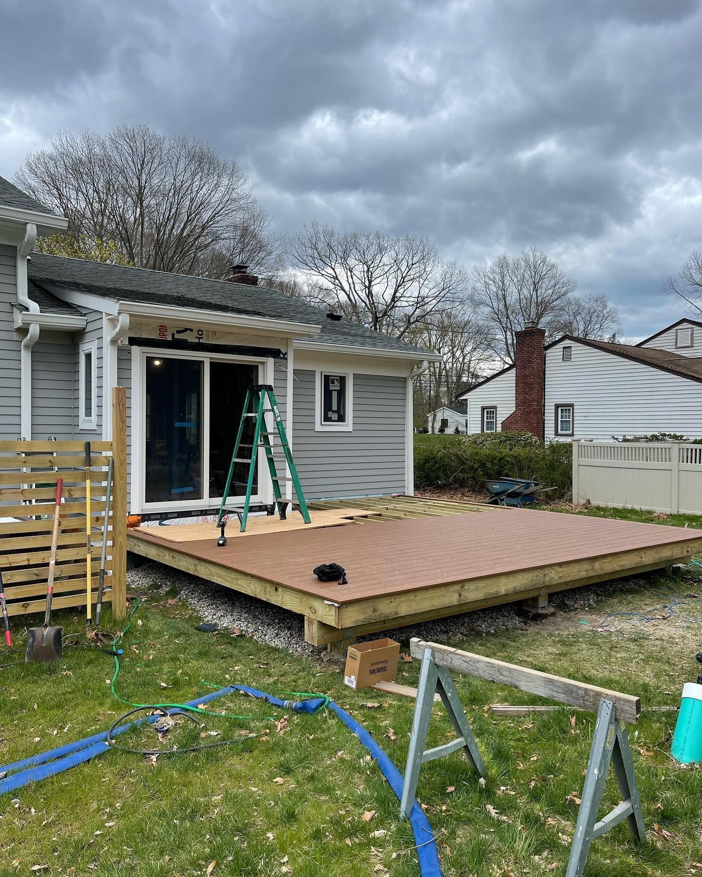A wooden deck is being built in the backyard of a house.