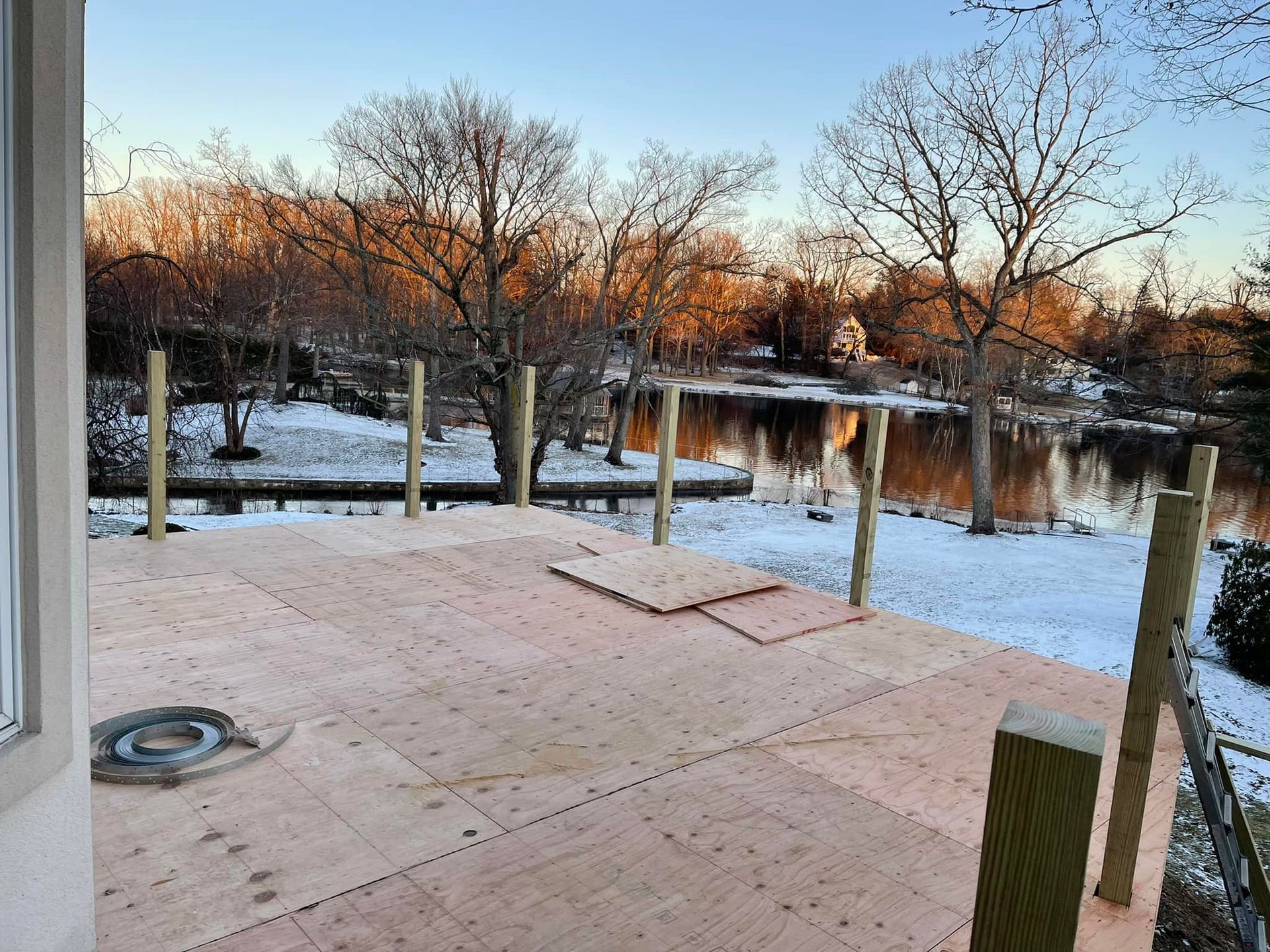 A wooden deck with a view of a lake and trees