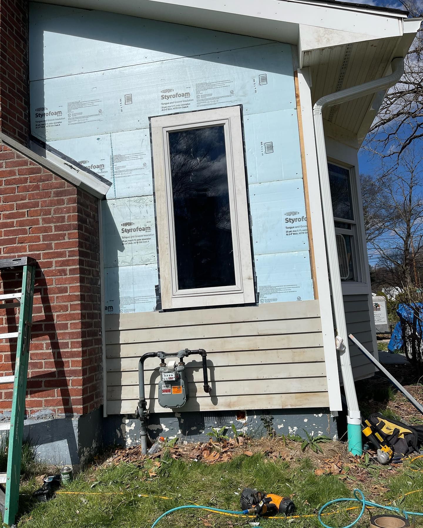 A window is being installed on the side of a house.