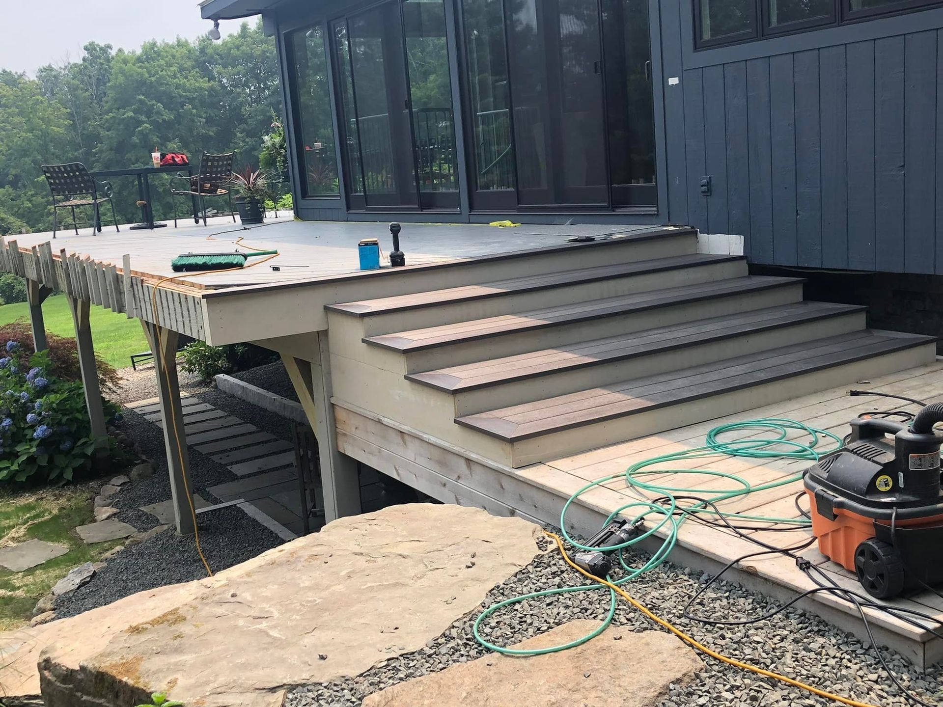 A deck with stairs and a vacuum cleaner on it.